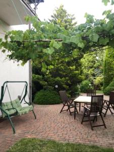 a patio with a swing and chairs and a table at "Kubania" POKOJE GOŚCINNE in Mielno
