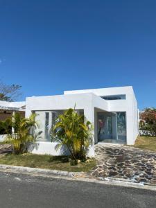 una casa blanca con palmeras delante en Moderna casa con piscina a 10 min de la playa en Coclé