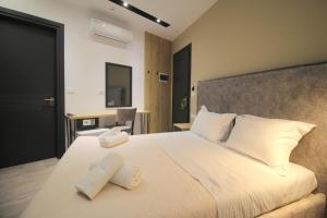 a bedroom with a large bed with two towels on it at F&J Hotel in Sarandë