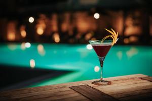 a drink in a glass sitting on a wooden table at L'Oasi Villaggio Albergo in Favignana