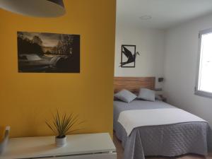1 dormitorio con 1 cama y una foto en la pared en A Casiña do Camiño, en Baamonde