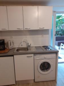 a kitchen with a sink and a washing machine at Apartments Belvedere in Rijeka
