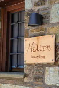 a sign on a building with a melanin luxury living sign at Μελίτη Pelion Luxury Living in Zagora