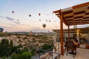 a balcony with hot air balloons in the sky at Fairyland Cave Hotel in Goreme