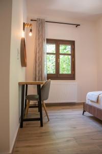 a bedroom with a desk and a bed and a window at Μελίτη Pelion Luxury Living in Zagora