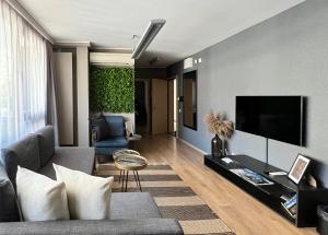 a living room with a couch and a flat screen tv at City Center Apartments in Plovdiv