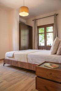 Μελίτη Pelion Luxury Living في زاغورا: غرفة نوم بسرير كبير ونافذة