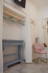 Camera con scrivania e sedia rosa di La Petite Maison a Conversano
