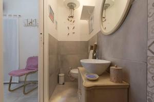 bagno con lavandino, servizi igienici e specchio di La Petite Maison a Conversano
