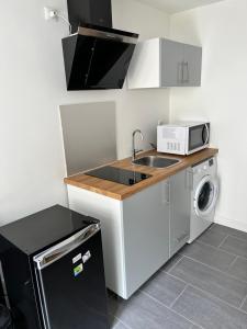 a small kitchen with a sink and a microwave at Logia in Ploërmel