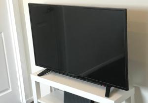 a flat screen tv sitting on a white stand at 2 DoubleBed Rooms Flat Aberdeen City, near University in Aberdeen