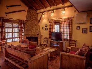 ein Wohnzimmer mit Kamin und Fernseher in der Unterkunft La Cañada del Valle del Jerte in Navaconcejo