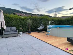 patio z basenem, krzesłem i stołem w obiekcie Appartementhaus FICHTERN w mieście Sankt Johann in Tirol