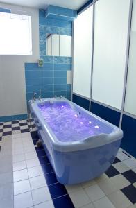 y baño con bañera grande de color púrpura. en Sanatory Nekhama en Kazán