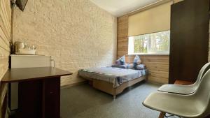 a bedroom with a bed and a desk and a window at Русалка in Szack