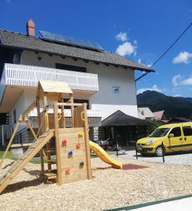 un parque infantil frente a un edificio con tobogán en Apartments Marica en Kranjska Gora