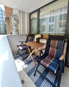 a patio with chairs and a wooden table on a balcony at City Center Apartments in Plovdiv