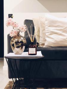 a table with a vase of flowers and a bed at Sal Serenity Suites in Santa Maria