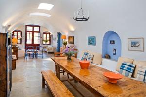 a living room with a wooden table and chairs at 3Arches by Thireon in Oia +18 photos