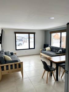 a living room with couches and a table and a dining room at Hábitat 268 in Esquel +15 photos