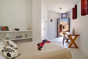 a bedroom with a bed and a table and a mirror at Villa Amalia by Thireon in Oia