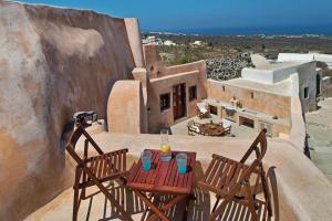 a balcony with two chairs and a table on a house at Villa Amalia by Thireon in Oia