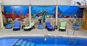 una piscina con sedie e un murale ad acquario di Posada Estrella a Salinas