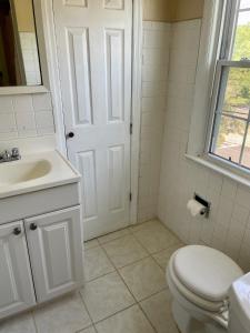 biała łazienka z toaletą i umywalką w obiekcie The Village - Entire 2nd Floor apartment with parking 