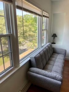 kanapę siedzącą w pokoju z oknami w obiekcie The Village - Entire 2nd Floor apartment with parking 