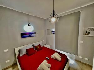 a bedroom with a red bed with two towels at Accogliente appartamento a due passi dalla metro in Moncalieri