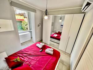 um quarto com uma cama vermelha e toalhas em Accogliente appartamento a due passi dalla metro em Moncalieri