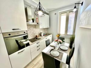 uma pequena cozinha com uma mesa e uma sala de jantar em Accogliente appartamento a due passi dalla metro em Moncalieri