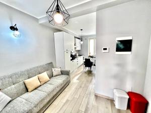 uma sala de estar com um sofá e uma cozinha em Accogliente appartamento a due passi dalla metro em Moncalieri