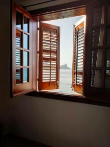 une fenêtre ouverte avec vue sur l'océan dans l'établissement Marettimo la casa sulla spiaggia, à Marettimo
