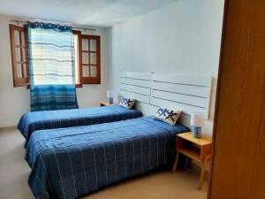 a bedroom with two beds and a window at Marettimo la casa sulla spiaggia in Marettimo