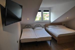 ウェバにあるAtlantic Łebaのベッド2台、薄型テレビが備わる客室です。