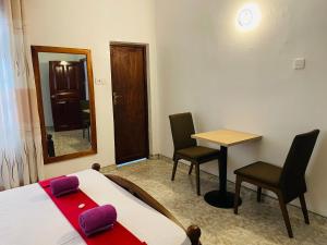 a bedroom with a bed and a table and two chairs at Ivana Homestay in Kandy