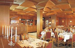 a dining room with tables and chairs in a restaurant at Hotel Austria in Niederau