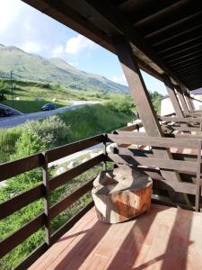drewniany płot z pniakiem drzewa stojący na ganku w obiekcie DONCIO`S Ski Hike & Bike Apartment w mieście Passo del Tonale