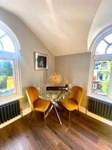 a dining room with a glass table and two chairs at 3 West End Boutique Apartment in Bowness-on-Windermere