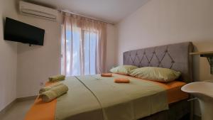 a bedroom with a bed with a television on the wall at Apartments Bellator in Šilo +177 photos