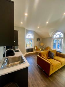 a kitchen and a living room with a couch at 3 West End Boutique Apartment in Bowness-on-Windermere