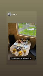 a table with food on it in a room with a window at Dutchdream b&b logcabin in Eighter