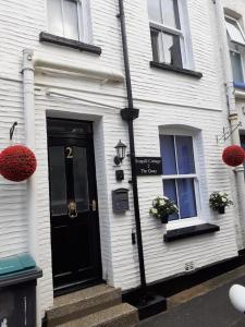 a white house with a black door and two windows at Seagull Cottage in Looe