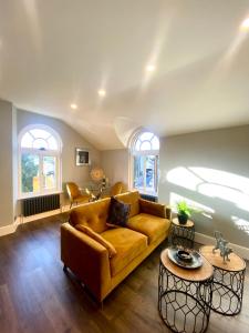 a living room with a yellow couch and two tables at 3 West End Boutique Apartment in Bowness-on-Windermere