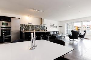 cocina y sala de estar con mesa y sillas en Eksklusiv ferielejlighed, en Rudkøbing