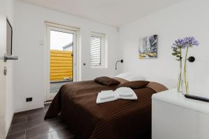 a bedroom with a bed with two white towels on it at Eksklusiv ferielejlighed in Rudkøbing