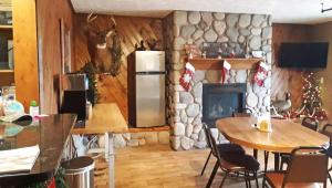 a kitchen with a table and a stone fireplace at Drop Tyne Lodge in Franklin