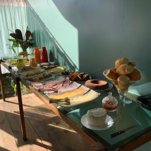 un tavolo con pane e altri prodotti alimentari di Pousada Sítio Itaúna a Penedo