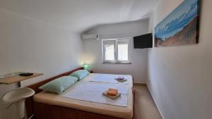 a small room with a bed and a window at Apartments Bellator in Šilo